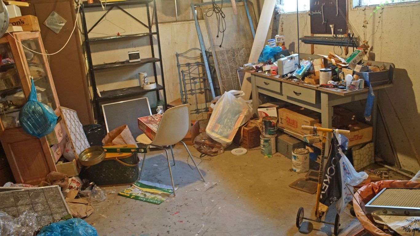 Cluttered basement filled with junk and household items, showing the need for professional hoarding cleanup.