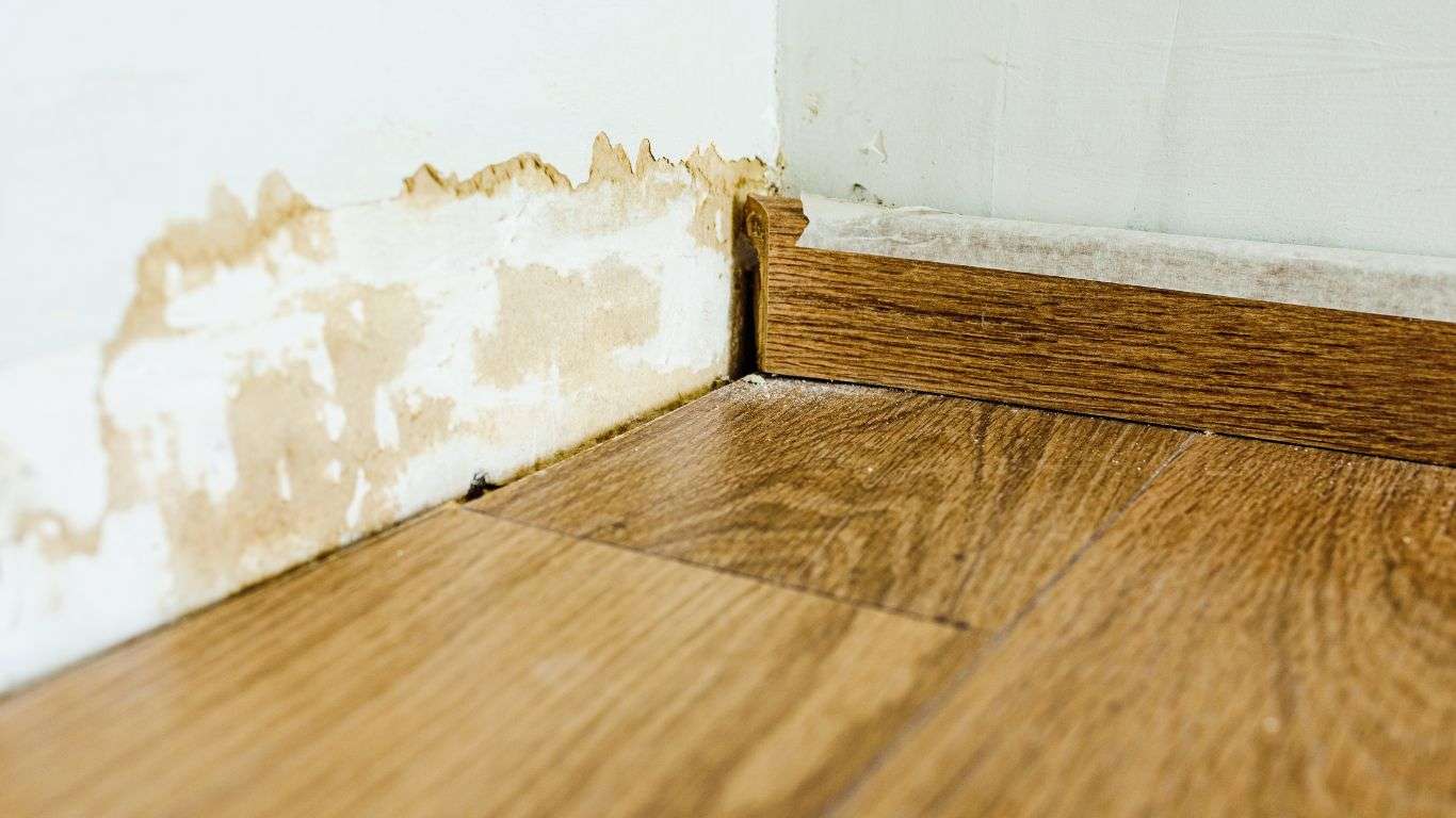 Interior wall and floor damage before professional water damage cleanup and restoration.